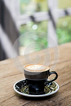 Hot cappuccino coffee cup with tree shape latte art milk foam on