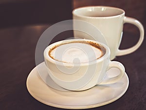 Hot cappuccino coffee in a drinking glass Placed on the table in a warm atmosphere. There is space for text