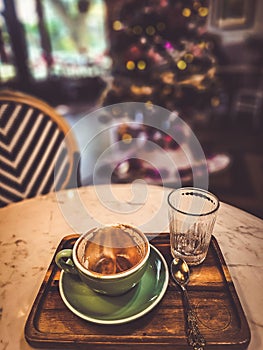 Hot cappuccino coffee in a drinking glass Placed on the table in a warm atmosphere. There is space for text