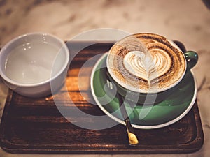 Hot cappuccino coffee in a mug Placed on the table in a warm atmosphere