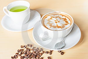 Hot cappuccino and green tea on wood table