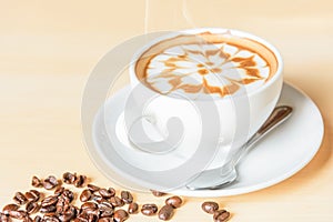 Hot cappuccino with nice milk pattern with coffee bean