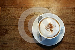 Hot Cappuccino in white cup on wood table