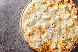 Hot cheese Alfredo pizza with chicken close-up on a wooden board. Horizontal top view