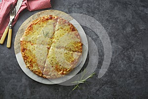 Hot cheeses delicious homemade pizza with thick crust on dark table, fast food. Copy space