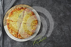 Hot cheeses delicious homemade pizza with thick crust on dark table, fast food. Copy space