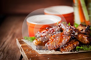 Hot chicken wings cooked with honey and soy, topped with sesame