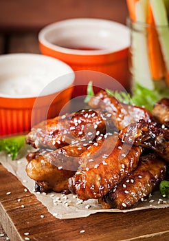 Hot chicken wings cooked with honey and soy, topped with sesame