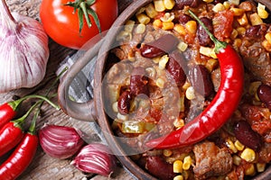 Hot chili con carne in a pot macro top view