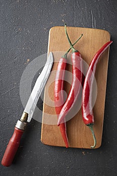 Hot chili pepper pods on a cutting board, close-up,