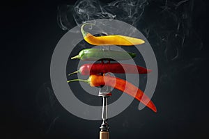 Hot chili peppers with smoke on a black background