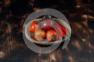 hot chili sauce, fresh tomatoes on tray with dark wooden background