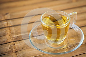 Hot chinese tea in glass with wood background