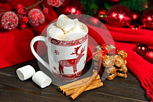 Hot chocolate or cocoa beverage with cinnamon and gingerbread cookies in snow vintage wooden table background.