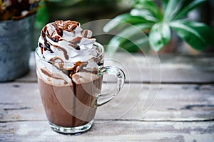 Hot chocolate cocoa in glass mug with whipped cream