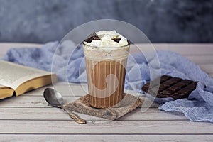 Hot chocolate or cocoa in glass with whipped cream and pieces chocolate