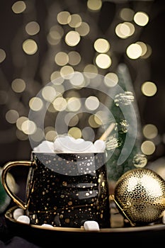 Hot chocolate cocoa with marshmallows on a black Christmas background with Golden bokeh