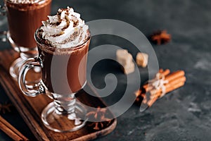 Hot chocolate cocoa with whipped cream in glass on dark background, copy space