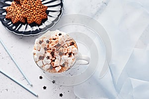 Hot chocolate or cocoa with whipped cream and marshmallow candy and Christmas gingerbread cookies