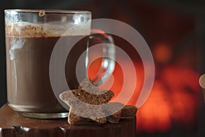 Hot chocolate and cookies with fireplace on the background
