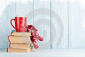 Hot chocolate cup and mittens over books