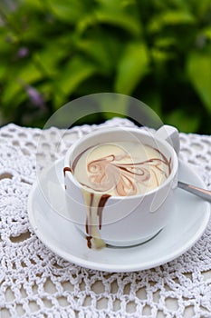 Hot chocolate cup on table at cafe outdoors summer. Coffee time and breakfast in restaurant. Chocolate, hot frothed milk