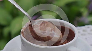 Hot chocolate cup on table at cafe outdoors summer. Coffee time and breakfast in restaurant. Chocolate, hot frothed milk