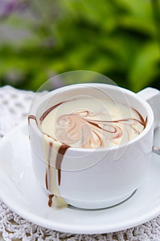 Hot chocolate cup on table at cafe outdoors summer. Coffee time and breakfast in restaurant. Chocolate, hot frothed milk