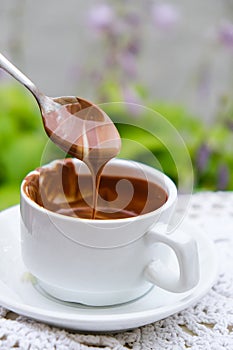 Hot chocolate cup on table at cafe outdoors summer. Coffee time and breakfast in restaurant. Chocolate, hot frothed milk