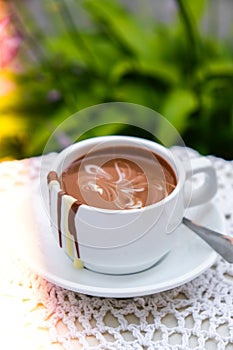 Hot chocolate cup on table at cafe outdoors summer. Coffee time and breakfast in restaurant. Chocolate, hot frothed milk