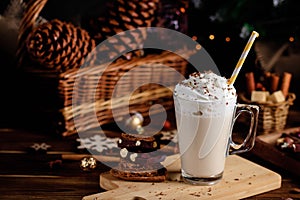 Hot chocolate drink with whipped cream. Cozy Christmas composition on a dark wooden background. Sweet treats for cold