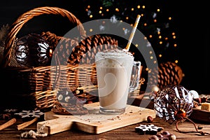 Hot chocolate drink with whipped cream. Cozy Christmas composition on a dark wooden background. Sweet treats for cold