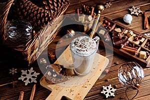 Hot chocolate drink with whipped cream. Cozy Christmas composition on a dark wooden background. Sweet treats for cold winter days.