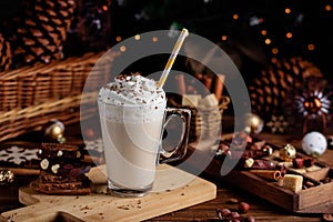 Hot chocolate drink with whipped cream. Cozy Christmas composition on a dark wooden background. Sweet treats for cold