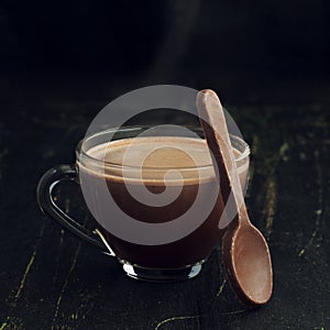 Hot chocolate in a glass cup and eatable chocolate spoon