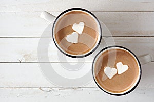 Hot chocolate with heart marshmallows over white wood