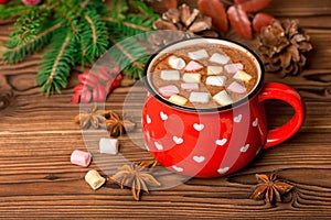 hot chocolate with marshmallow candies on wooden background decorated Christmas tree branch, cones and anis, greeting card