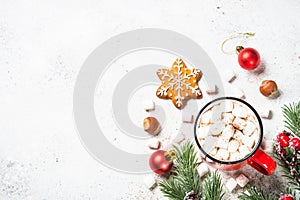 Hot chocolate with marshmallow and christmas cookies at white table.