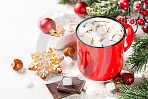 Hot chocolate with marshmallow and christmas cookies at white table.