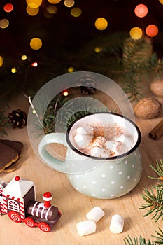 Hot chocolate with marshmallow, Christmas traditional cocoa drink on bokeh of lights. Festive winter atmosphere