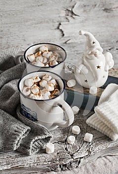 Hot chocolate with marshmallows, ceramic Santa Claus, old book and gloves