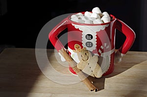 Hot chocolate Mrs. Clause cute mug with marshmallows, cinnamon, gingerbread on wooden table with copy space