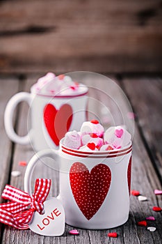 Hot chocolate with pink marshmallow in mugs with hearts for Valentine day