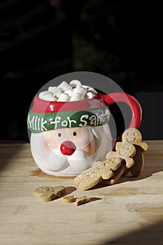 Hot chocolate Santa Clause cute mug with marshmallows, and gingerbread cookies on wooden table