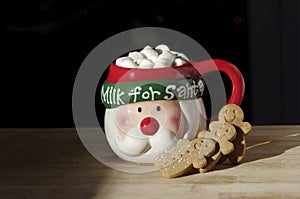 Hot chocolate Santa Clause cute mug with marshmallows, and gingerbread on wooden table with copy space