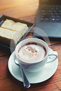 Hot chocolate is served with hot bread between the notebook.