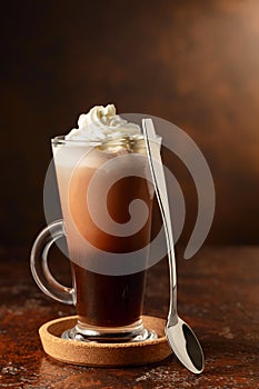 Hot chocolate with whipped cream in a glass mug