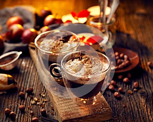 Hot chocolate with whipped cream, sprinkled with aromatic cinnamon in glass cups