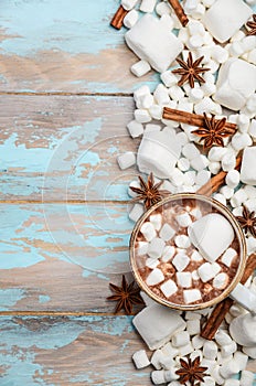 Hot Chocolate, White Marshmallows and Winter Spices on Blue Wooden Background