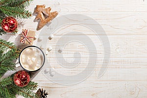 Hot Christmas drink with marshmallows in an iron mug and gingerbread cookies, on a white table. New Year, holiday background,